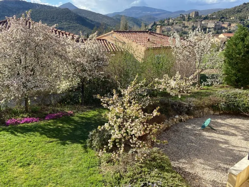 De tuin in het voorjaar vol bloesem, met Montbrun-les-Bains en zijn kasteel in de verte