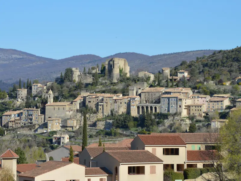 Montbrun-les-Bains op zijn heuvel, met de kasteelruïne, de kerktoren en de arcaden